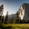 landmark photography of trees near rocky mountain under blue skies daytime